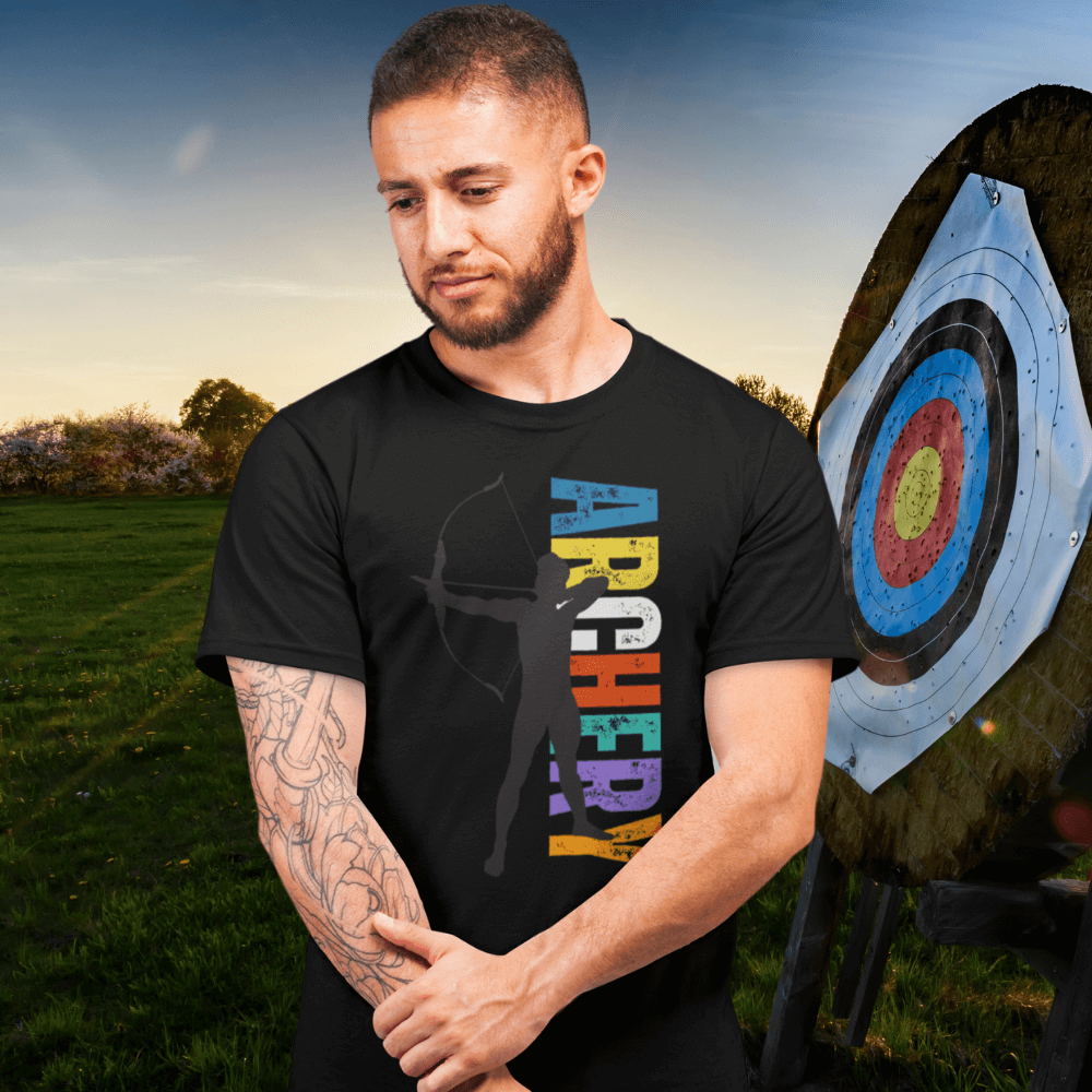 Man wearing Men's Vintage Archery Silhouette T-Shirt stands next to a target outdoors at sunset.