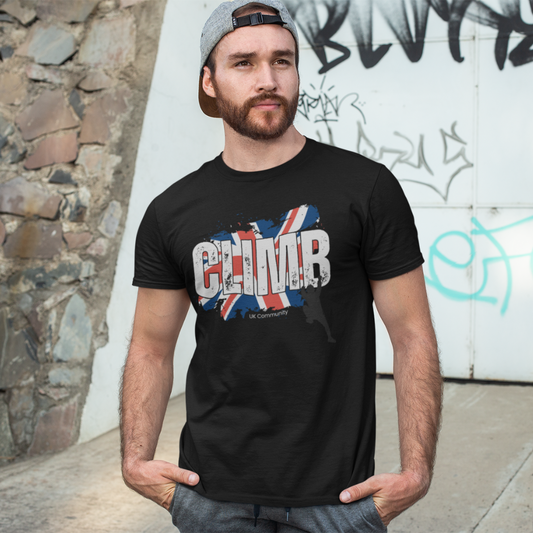 Man wearing UK climbing community t-shirt with Union Jack and climber silhouette design, standing outdoors.